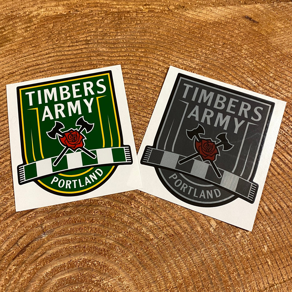 Two vinyl cutout stickers with the New Timbers Army crest. One sticker is the crest in green and yellow, the other has the crest in greytones, and both have the classic Axe and Rose in red.